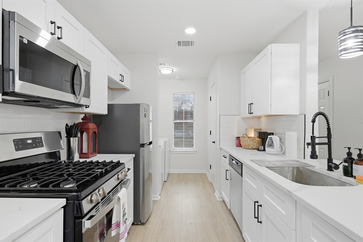 fully stocked big new kitchen with oven, microwave, cook top, fruig, and washer/dryer