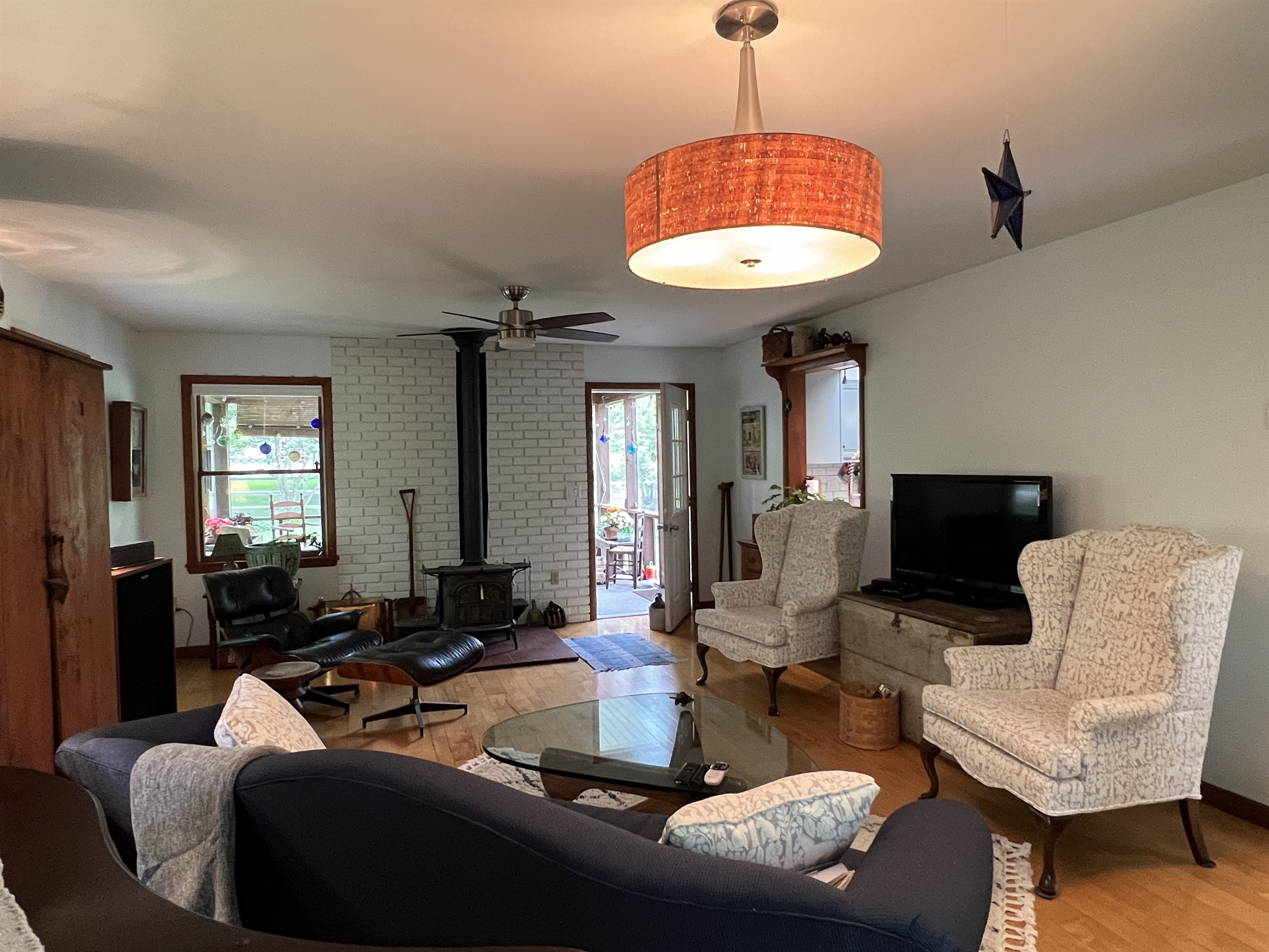 Living room view onto the private screened-in porch and  window into the kitchen.