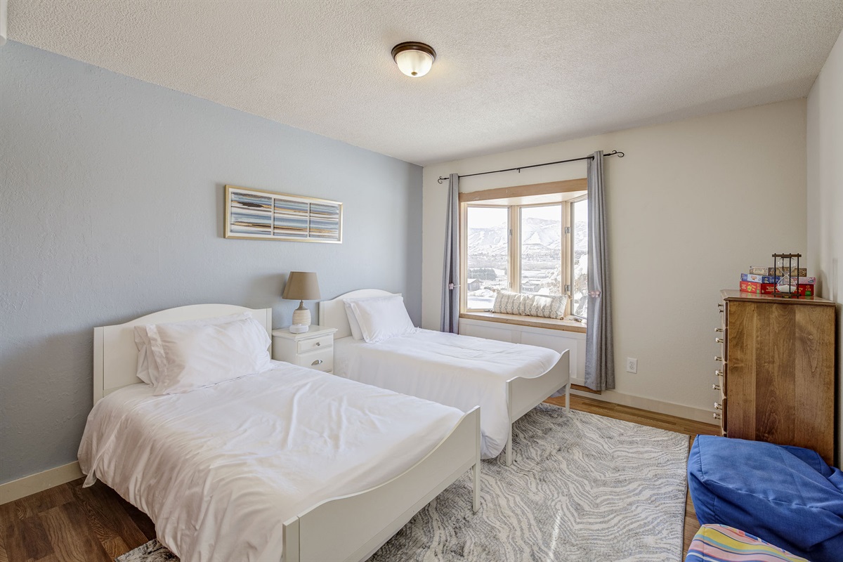 Twin beds with bay window and views of the Wenatchee Valley & Cascade Mountains.