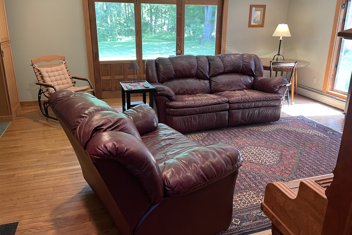 Leather lounging in the living room, w/ door leading outside.