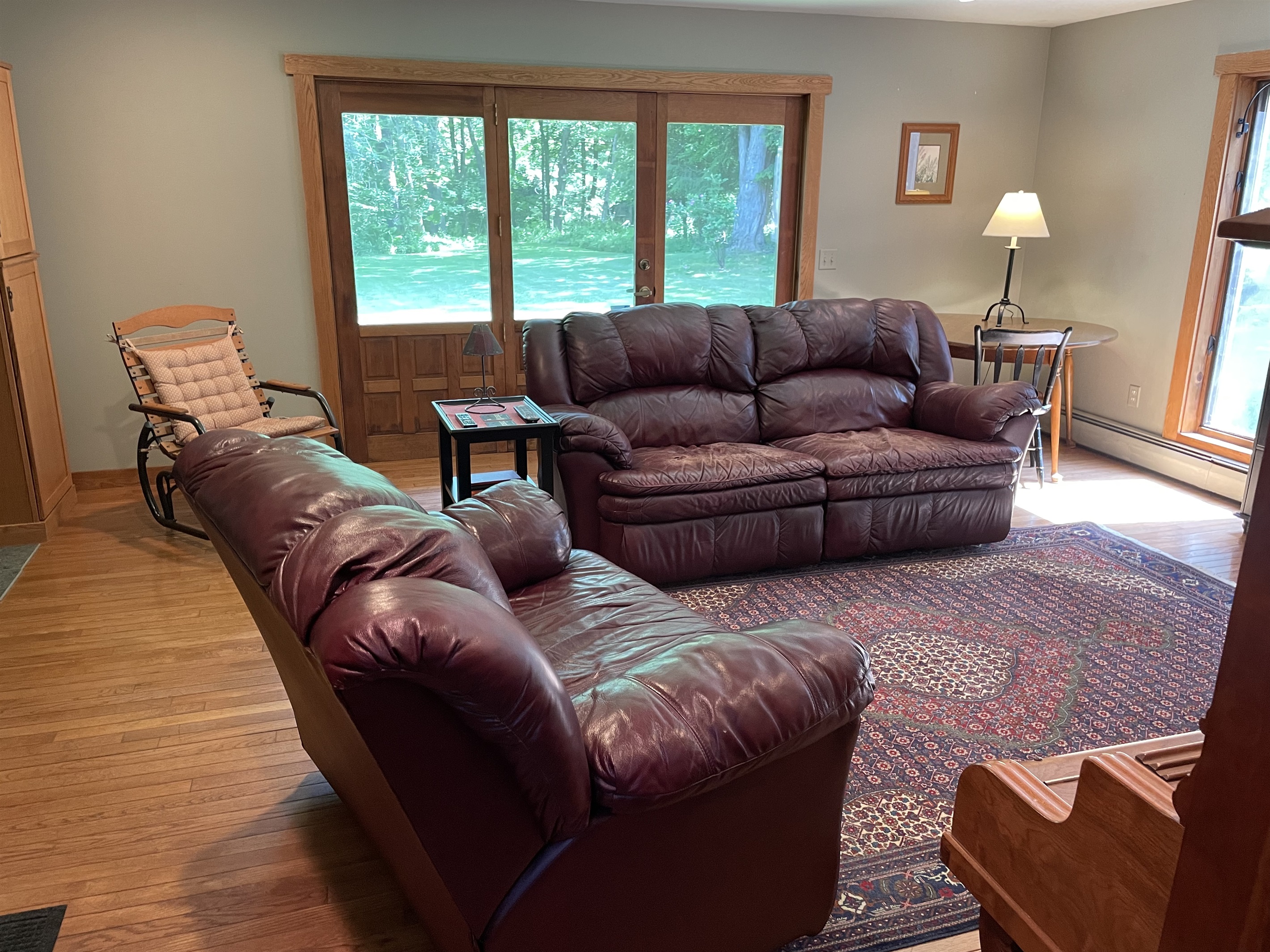 Leather lounging in the living room, w/ door leading outside.