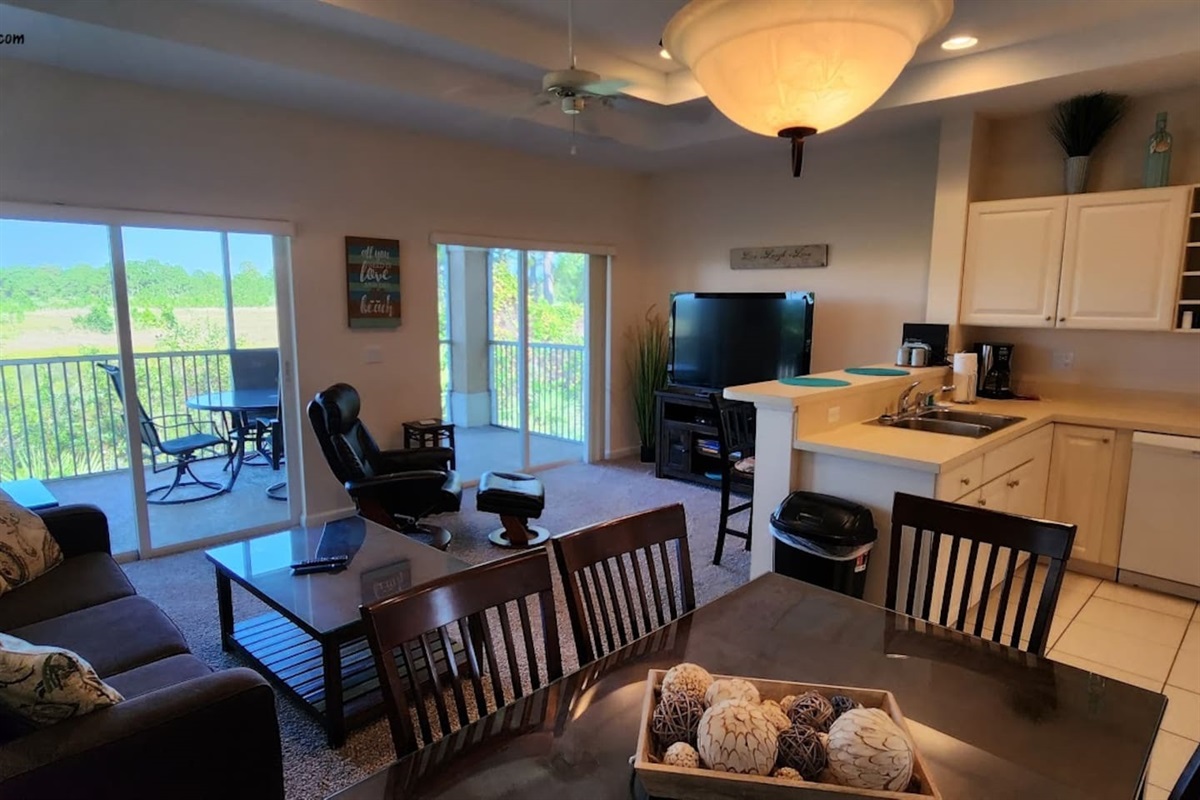 Spacious open-concept living and dining area with sliding glass doors leading to the private screened balcony.