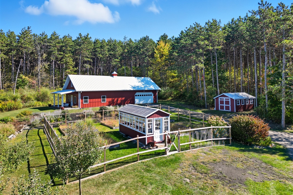 Charming countryside setup with a classic red barn, garden space, and outbuildings—perfect for hobby farming or a serene retreat.
