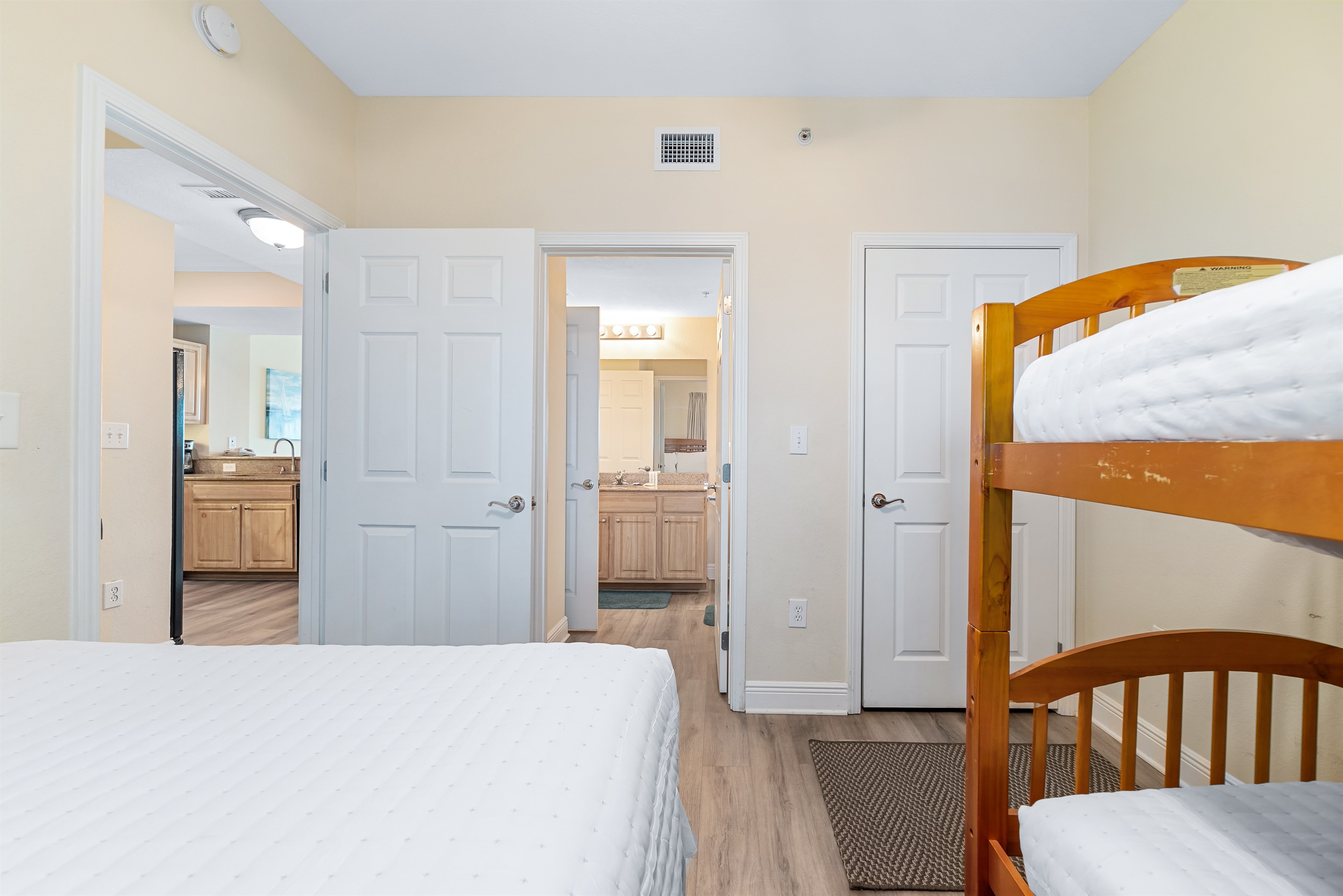 This interior showcases efficient space utilization with a stylish queen and bunk bed arrangement. The thoughtful design maximizes comfort and functionality, creating a versatile room.