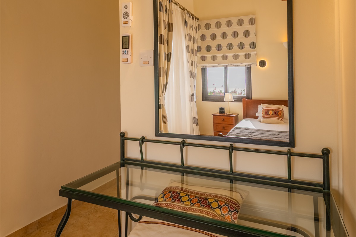 Master king ensuite bedroom with sea views and terrace access. King size bed, ceiling fan, dedicated AC/heating unit, vanity, large built-in wardrobes, bluetooth speaker/alarm clock.