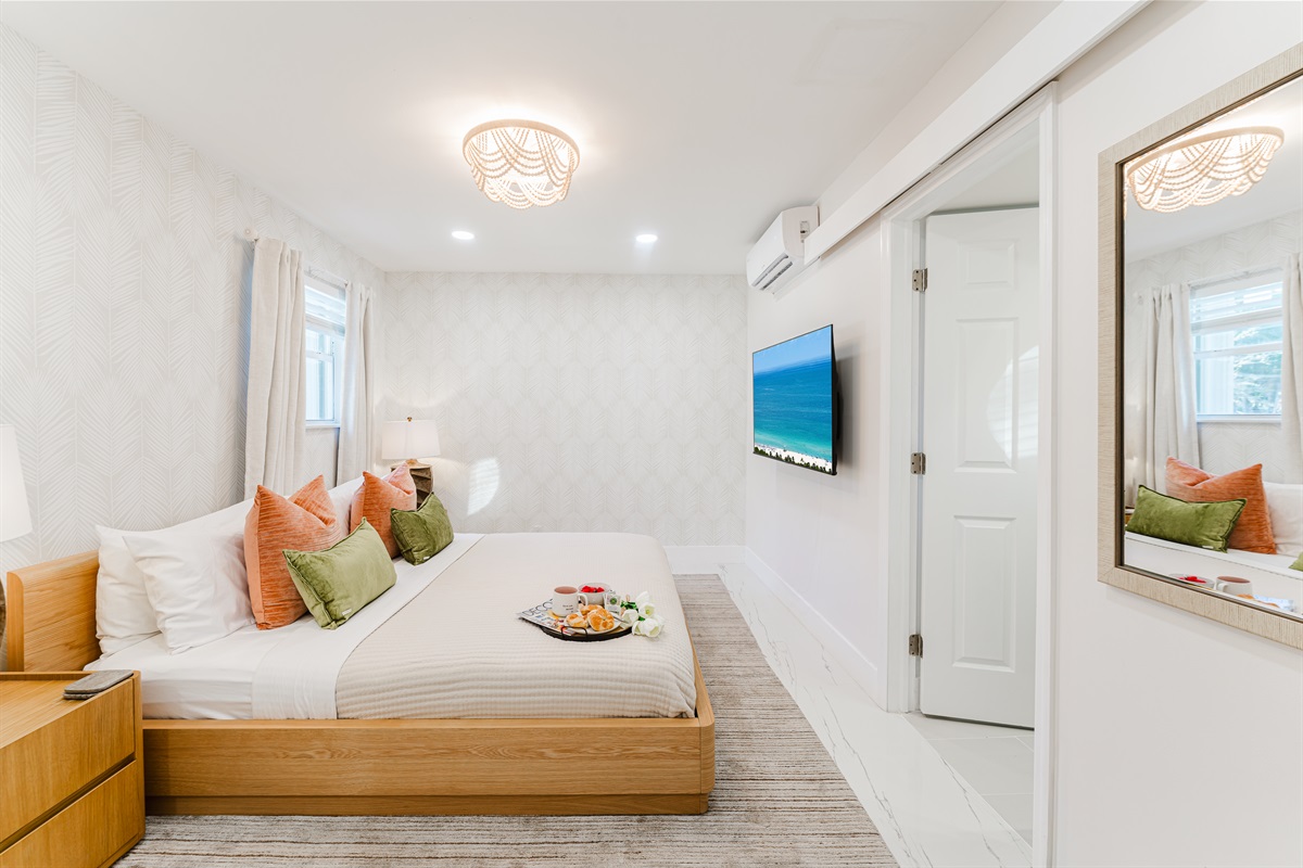 Primary king suite designed for rest and privacy, featuring fresh cotton linens, a Smart TV, and serene Palm Beach–inspired finishes. Includes a walk-in closet and private en-suite bathroom for a comfortable, hotel-style stay.