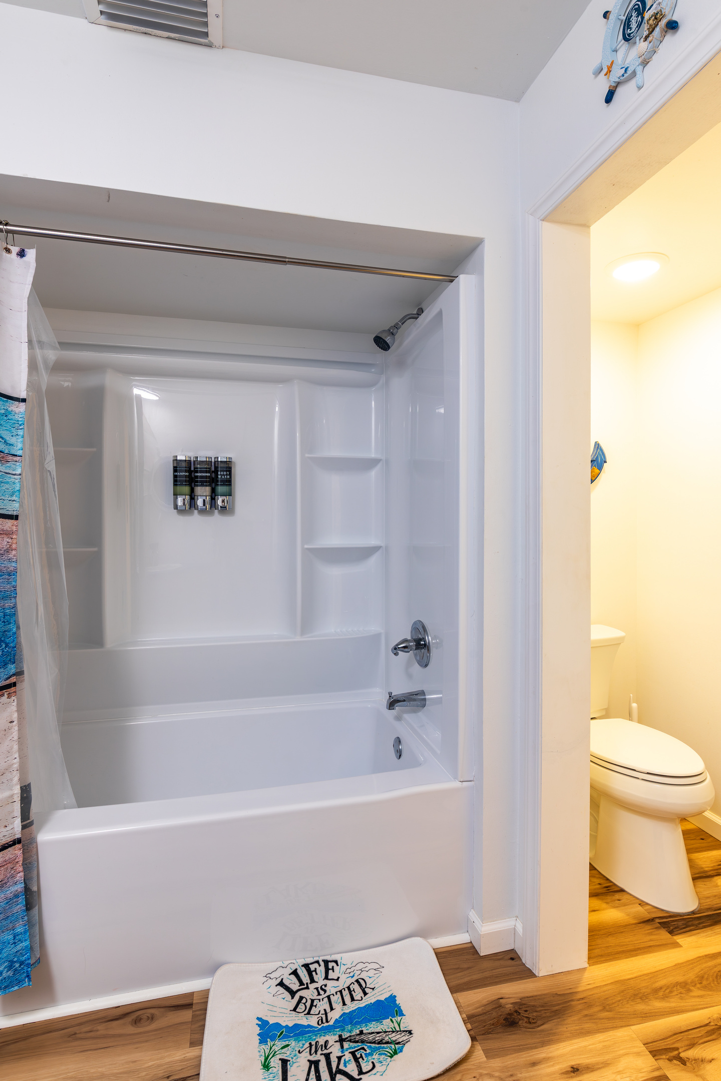 The downstairs common bathroom includes a full tub-shower combination for families and larger groups.