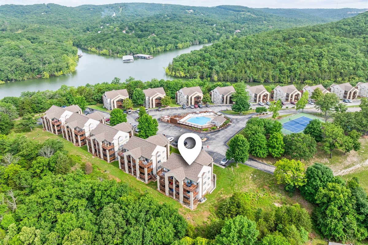 Aerial view of Indian Point Cove, showcasing the lakeside setting, community pool, tennis courts, and surrounding wooded hills.