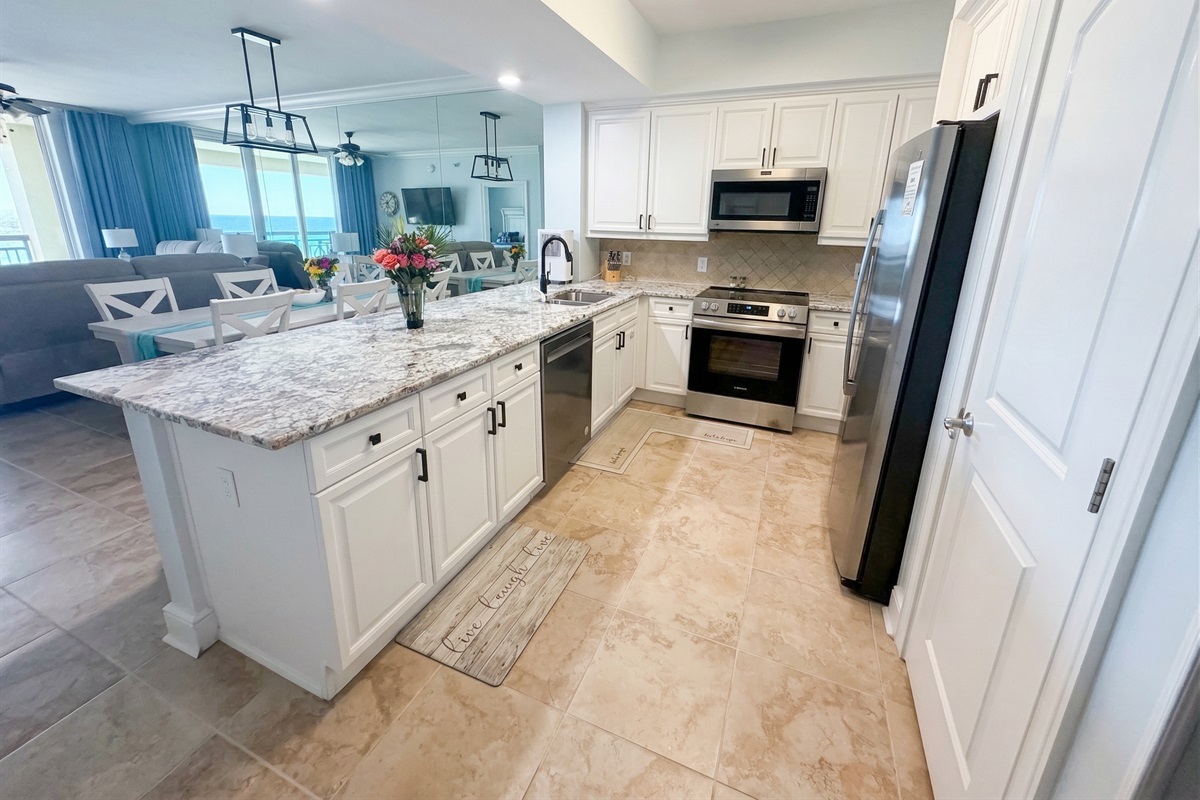 Spacious kitchen with granite countertops, stainless appliances, and bar seating—perfect for coffee mornings or family meals together.