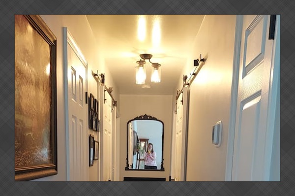 This is the hallway. Two bathrooms face each other, each equipped with sliding barn doors to optimize space. Additionally, there are two hallway closets—one housing the WiFi system and the other designated for cleaning supplies.