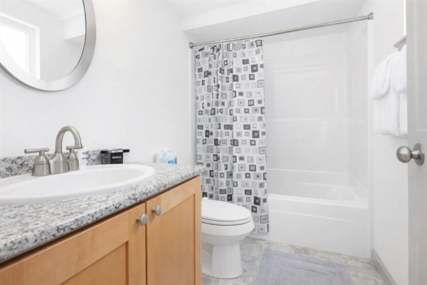 Bathroom Bliss: Modern granite countertops and fresh amenities await your seaside retreat!