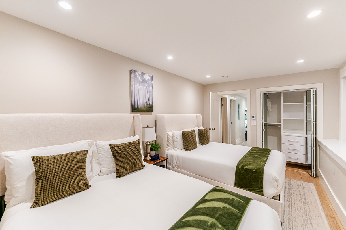 Large bedroom w/ 2 brand new Avocado Green queen beds & luxury bedding, 3 nightstands w/ built-in charging stations, built-in closet for storage & 65" NeoQLED 4k smart TV