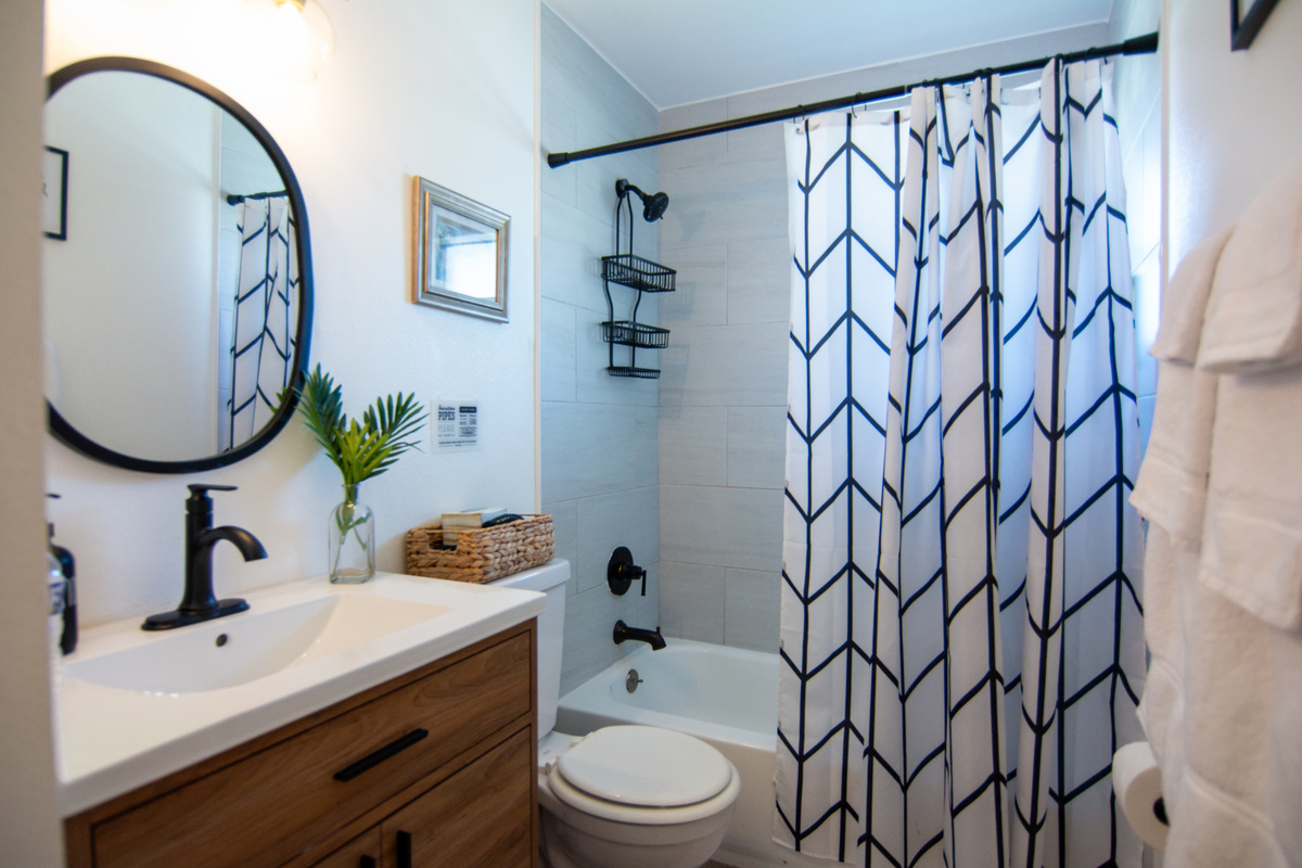 Bathroom with tub/shower combo, modern vanity and hotel-style toiletries