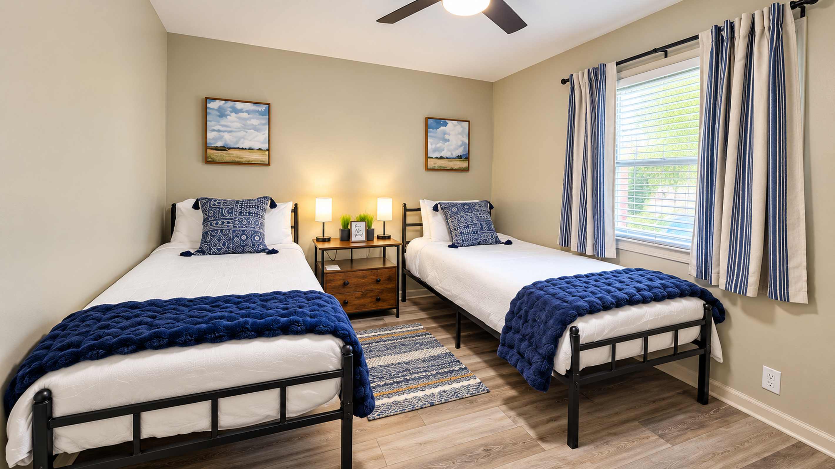 Two comfortable twin XL beds with crisp linens, navy accents, and individual bedside lamps.