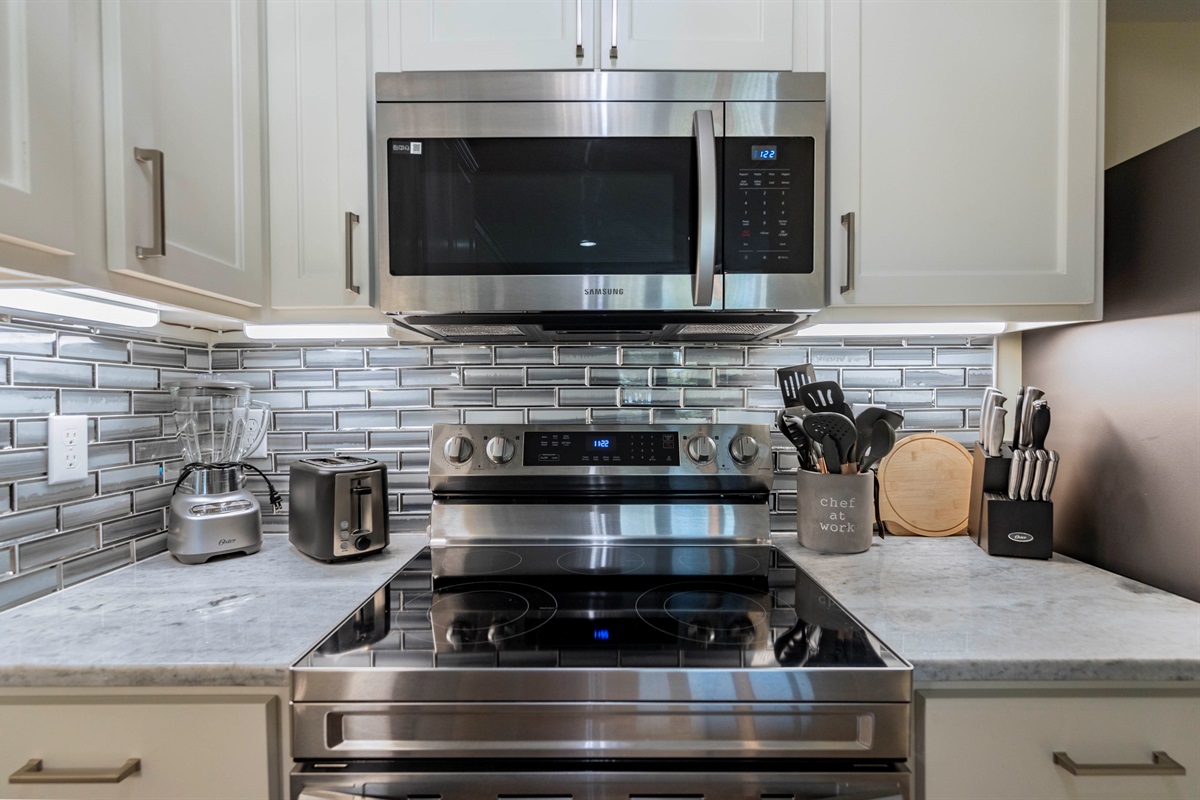 Modern kitchen with sleek stainless steel appliances and stylish backsplash.