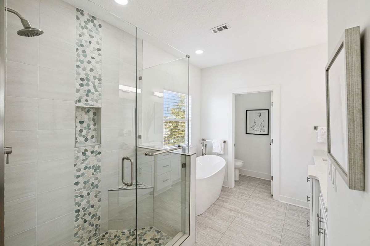 Sleek glass-enclosed walk-in shower featuring decorative stone accents for a true spa-like retreat