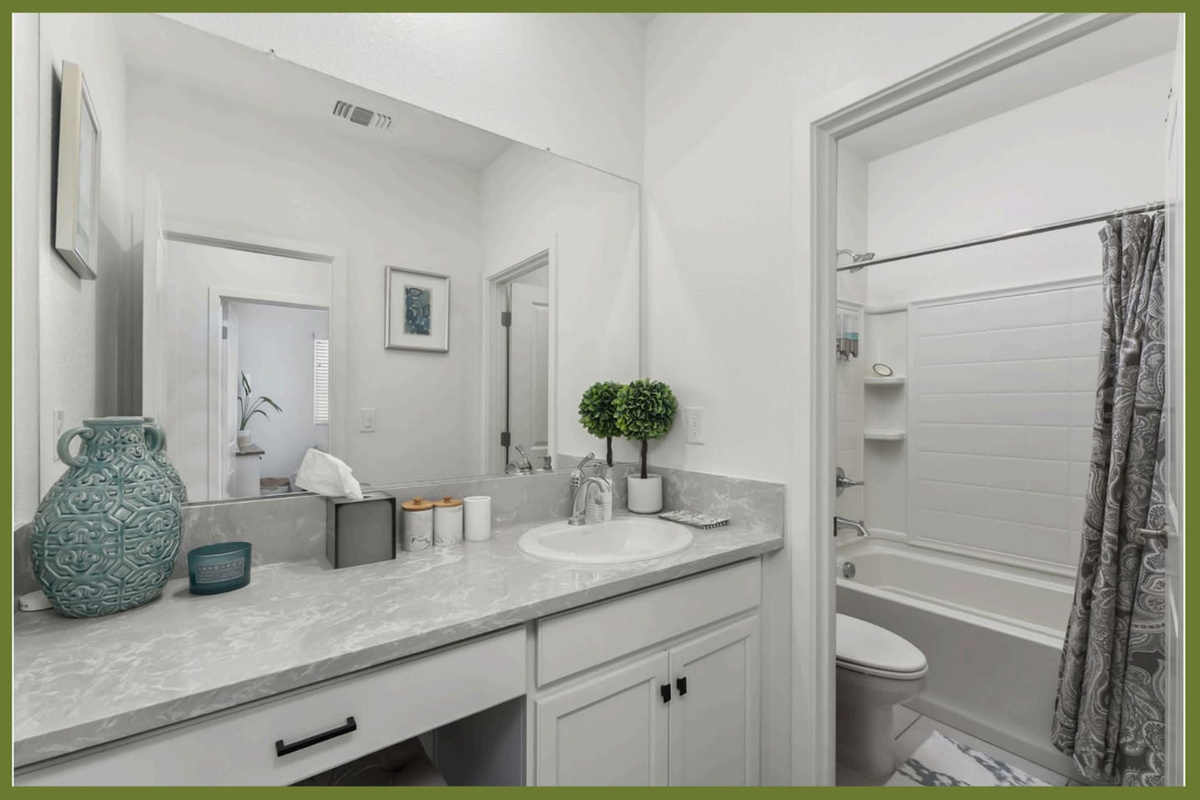 Bathroom vanity with counter space, storage cabinet, and easy access to the nearby shower/tub combination.