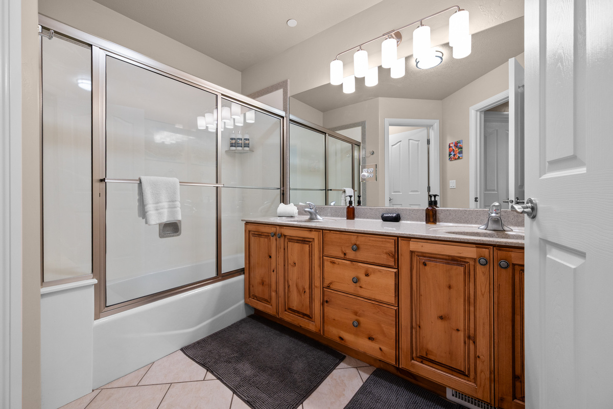 Spacious downstairs bathroom with a large vanity and ample counter space, plus a convenient tub/shower combo for guests and families.