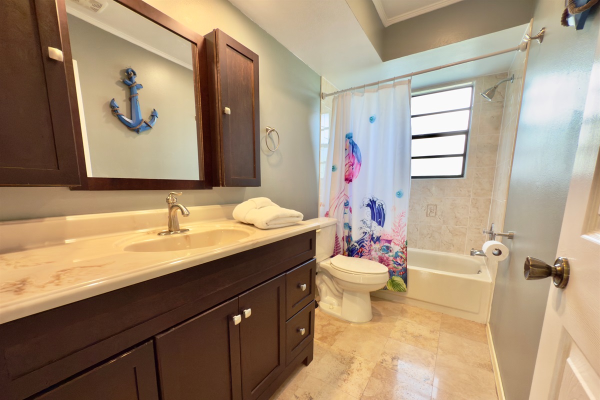 Soft, overhead lighting complements the natural light streaming in from the frosted privacy window, creating a bright yet soothing environment throughout the day.