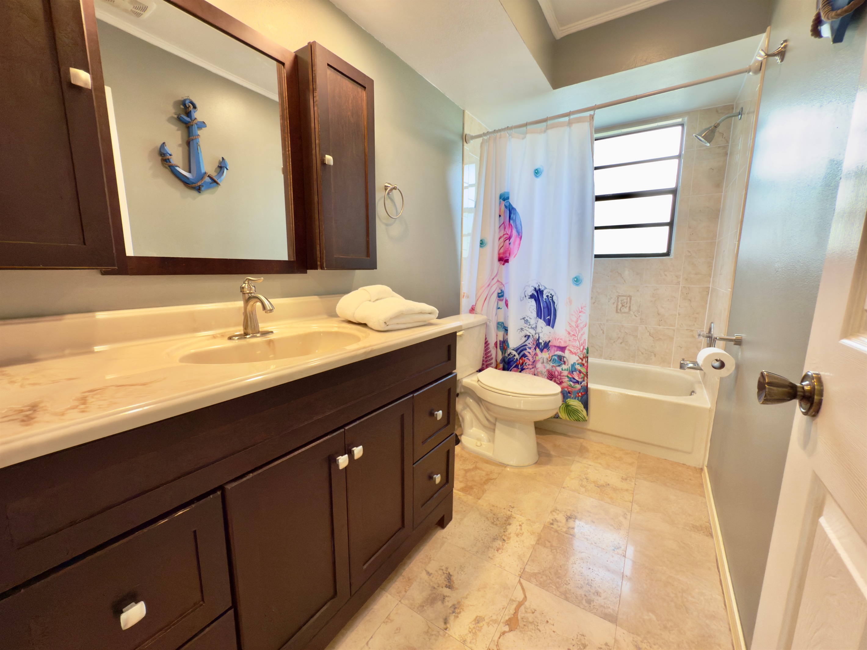 Soft, overhead lighting complements the natural light streaming in from the frosted privacy window, creating a bright yet soothing environment throughout the day.