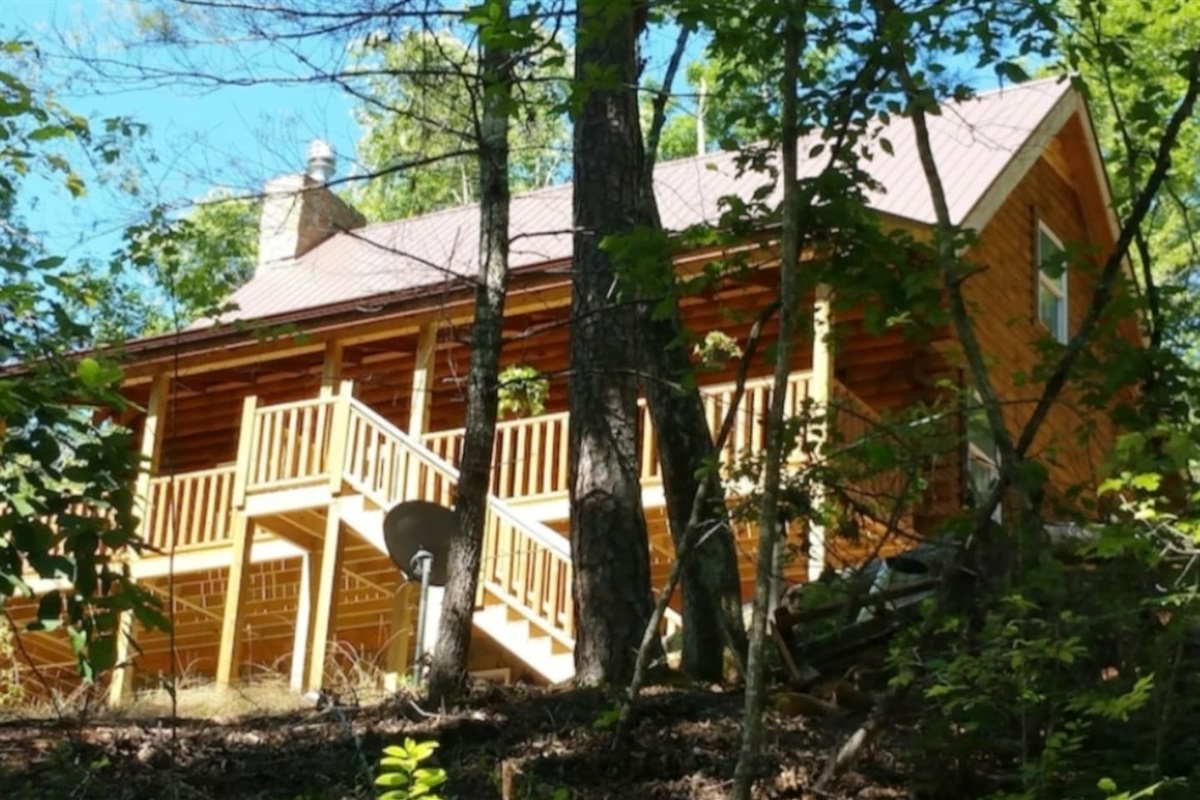 Large, private 3 story log cabin in private setting with large property, stream  and trails behind cabin. Walking distance to private lakes, beach and river. Canoe available