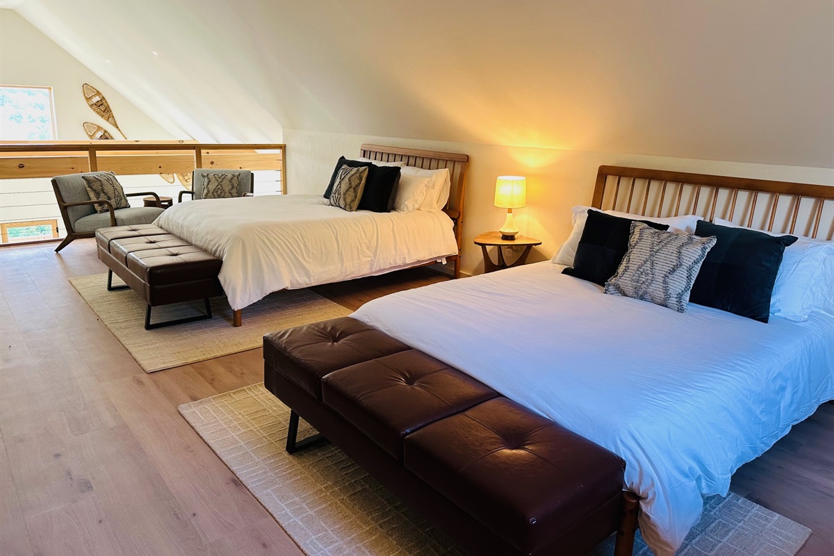 Loft sleeping area with two queen beds and sitting space