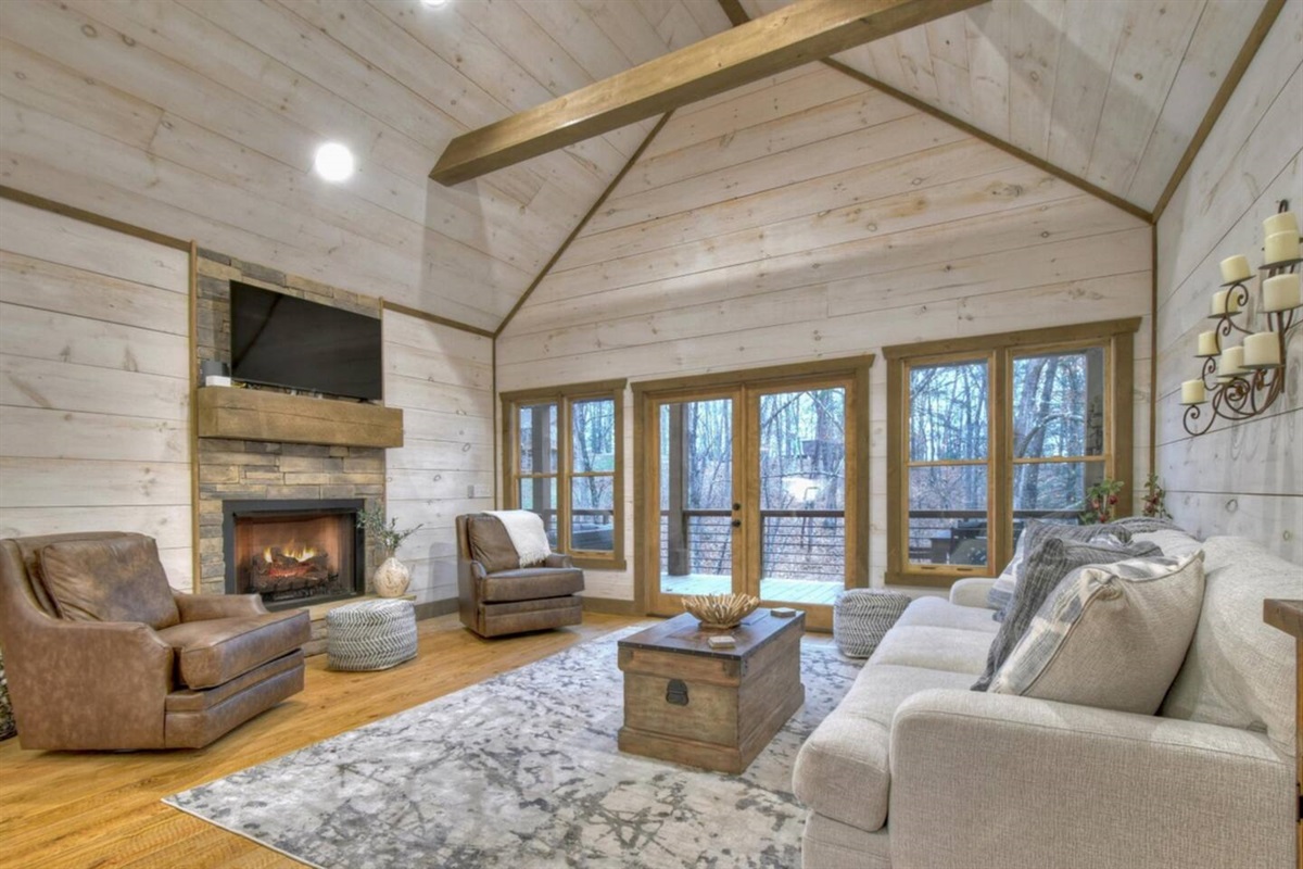 Main floor living room with indoor fireplace and access to outdoor fireplace, porch swing, grill and dining area.  Living room as 3 seat sofa and two chairs.