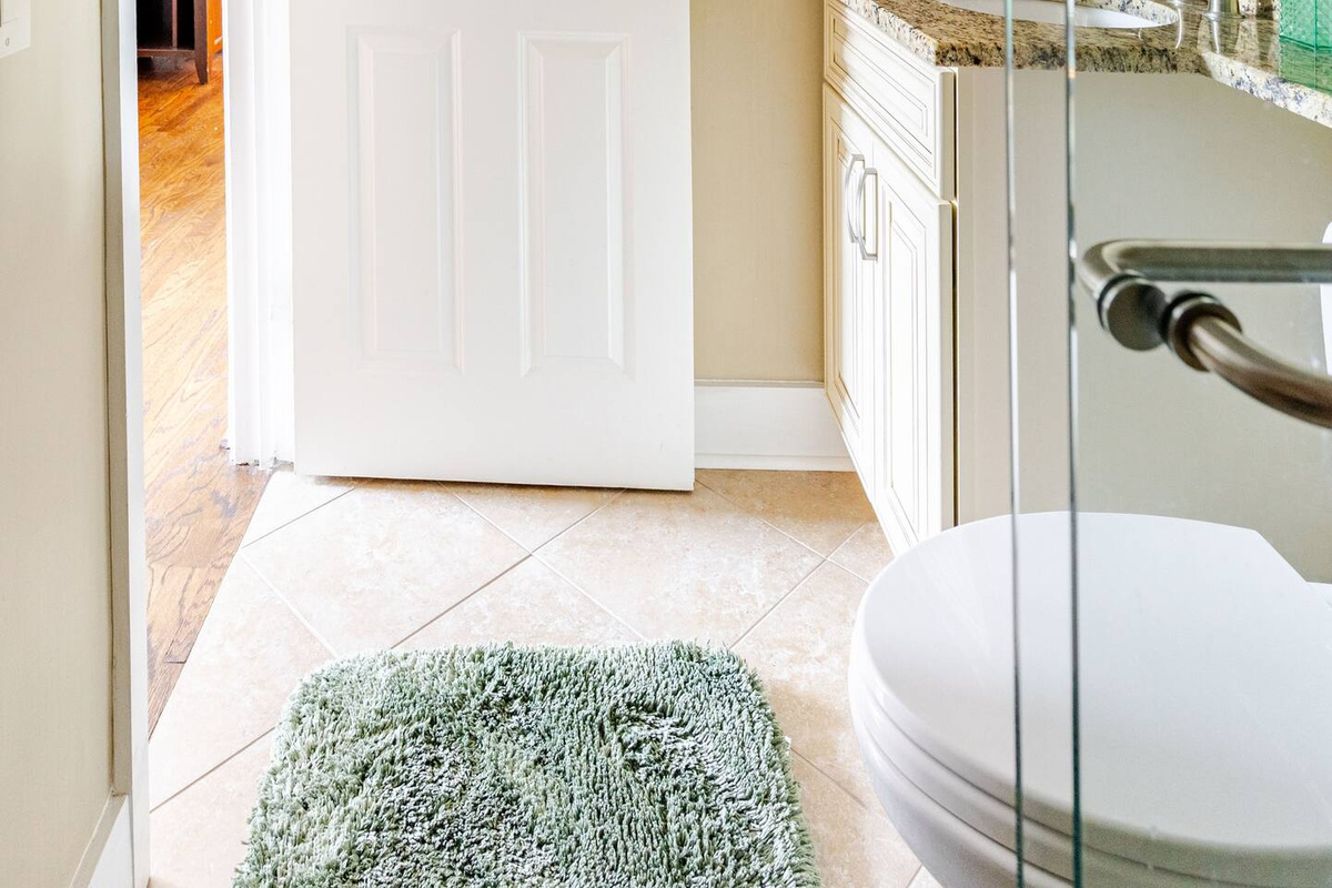 A beautifully appointed guest bathroom featuring a comfortable sitting chair for added convenience and comfort.