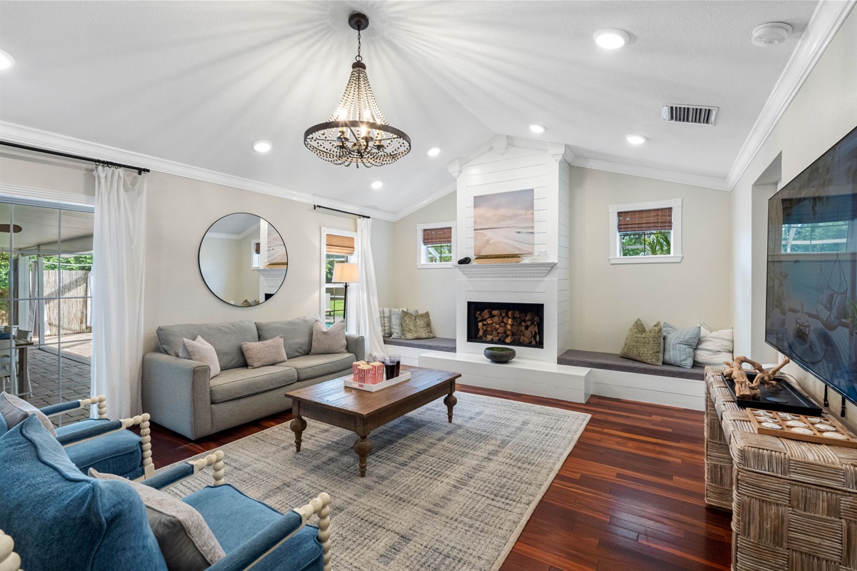 A stunning chandelier crowns the vaulted ceiling, creating a touch of elegance in this bright and airy living space.