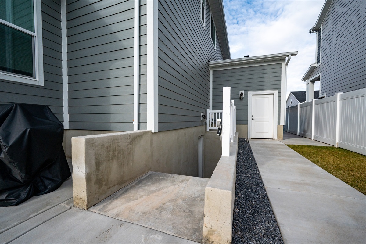 Private side walkway offering easy access and convenient trash area.