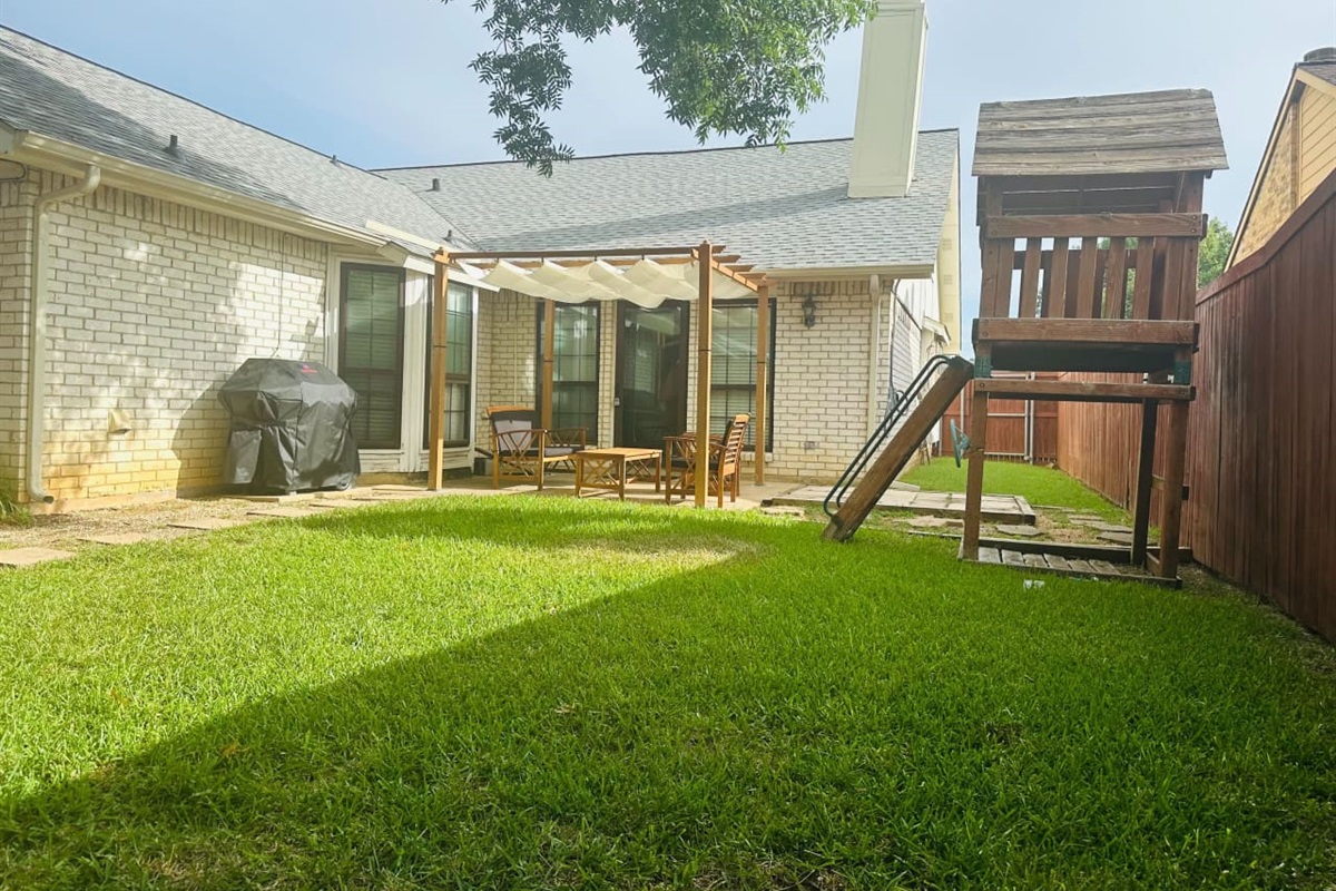 Backyard retreat with grill, seating, and space for entertaining.