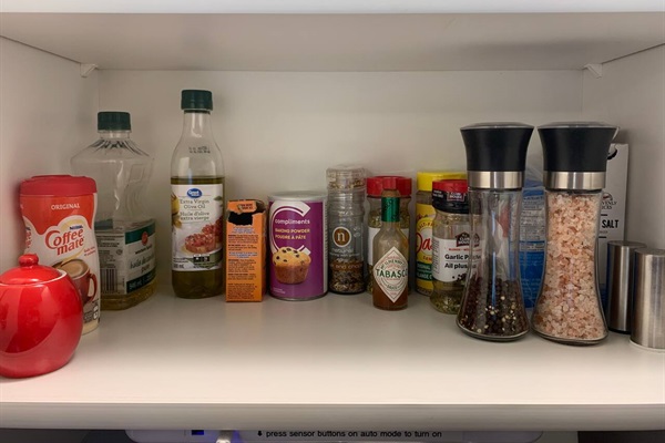 Kitchen stocked with cooking spices and seasonings, oils, and sugar.