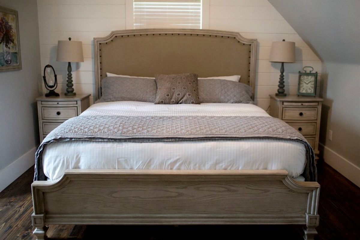 King-size bed in upstairs bedroom of cozy cabin