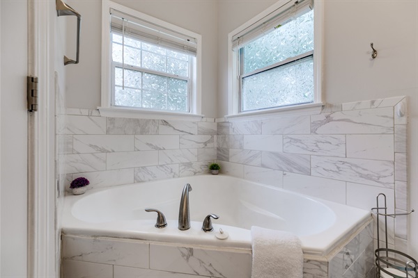 A spa-like escape awaits: bubble baths, soft lighting, and pure relaxation in your own corner garden tub.