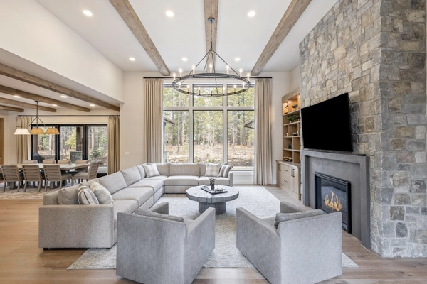 Soaring great room with walls of windows, forest views, gas fireplace and plenty of room to gather