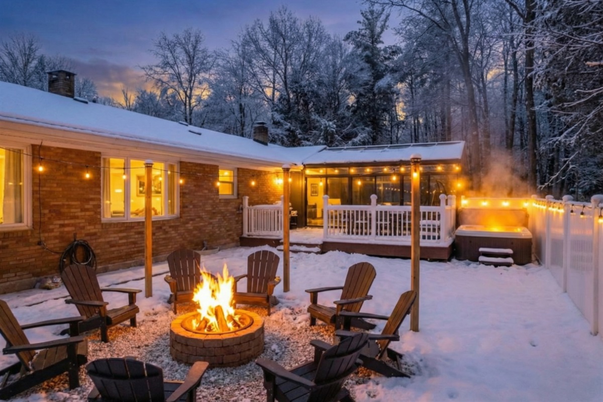 Backyard at night in snow w/firepit and lights
