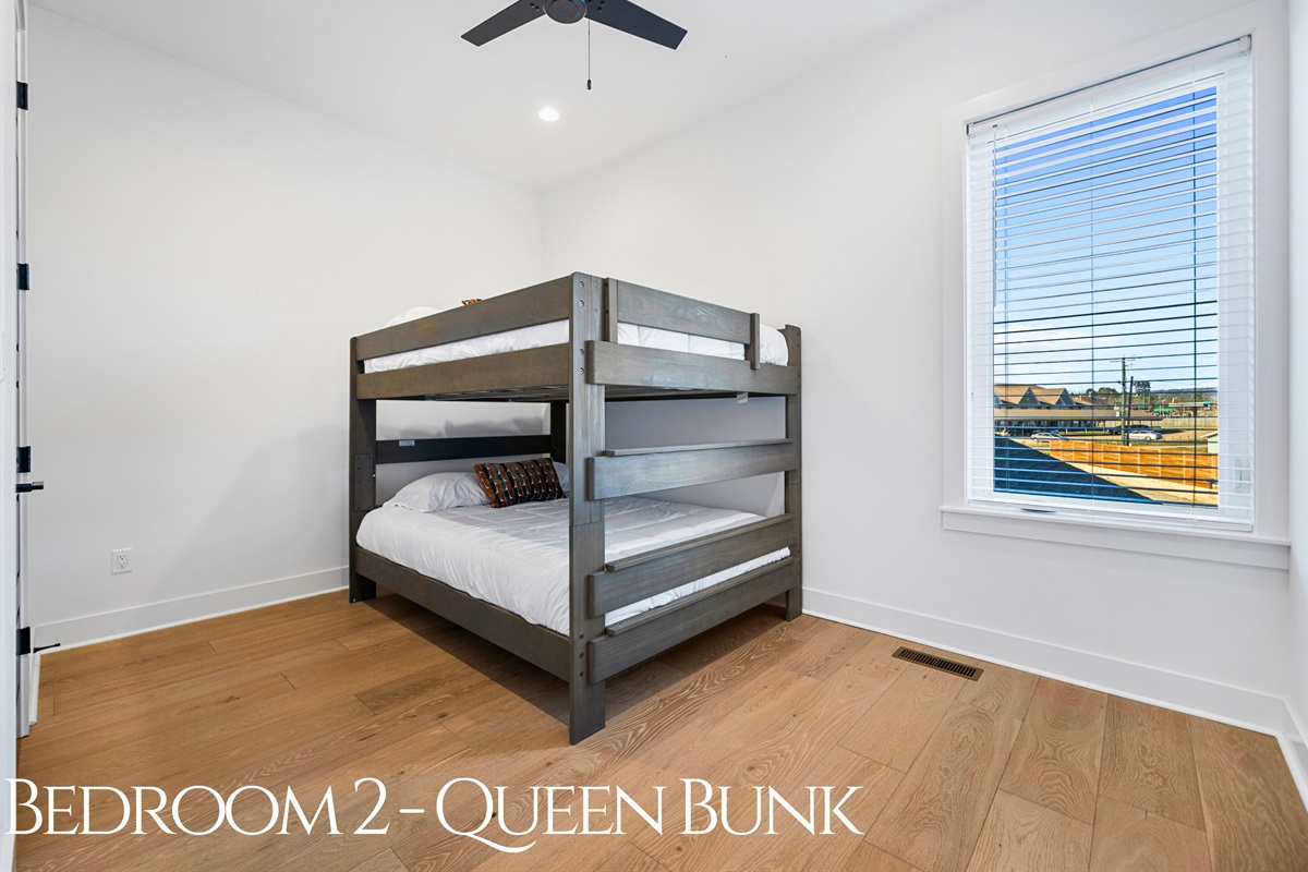 This bunk room is designed for comfort and fun, with a queen-over-queen setup, plenty of natural light, and warm wood tones that create a welcoming space.