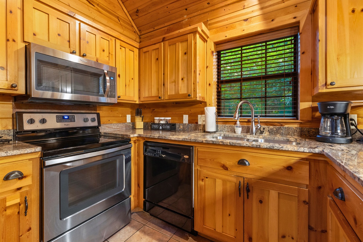 Stainless appliances and cabin-style cabinetry in the kitchen.