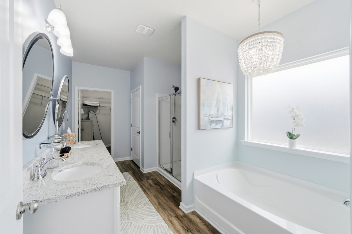 Primary Bathroom with double vanity with elegant finishes, Separate tub and walk-in shower for ultimate convenience