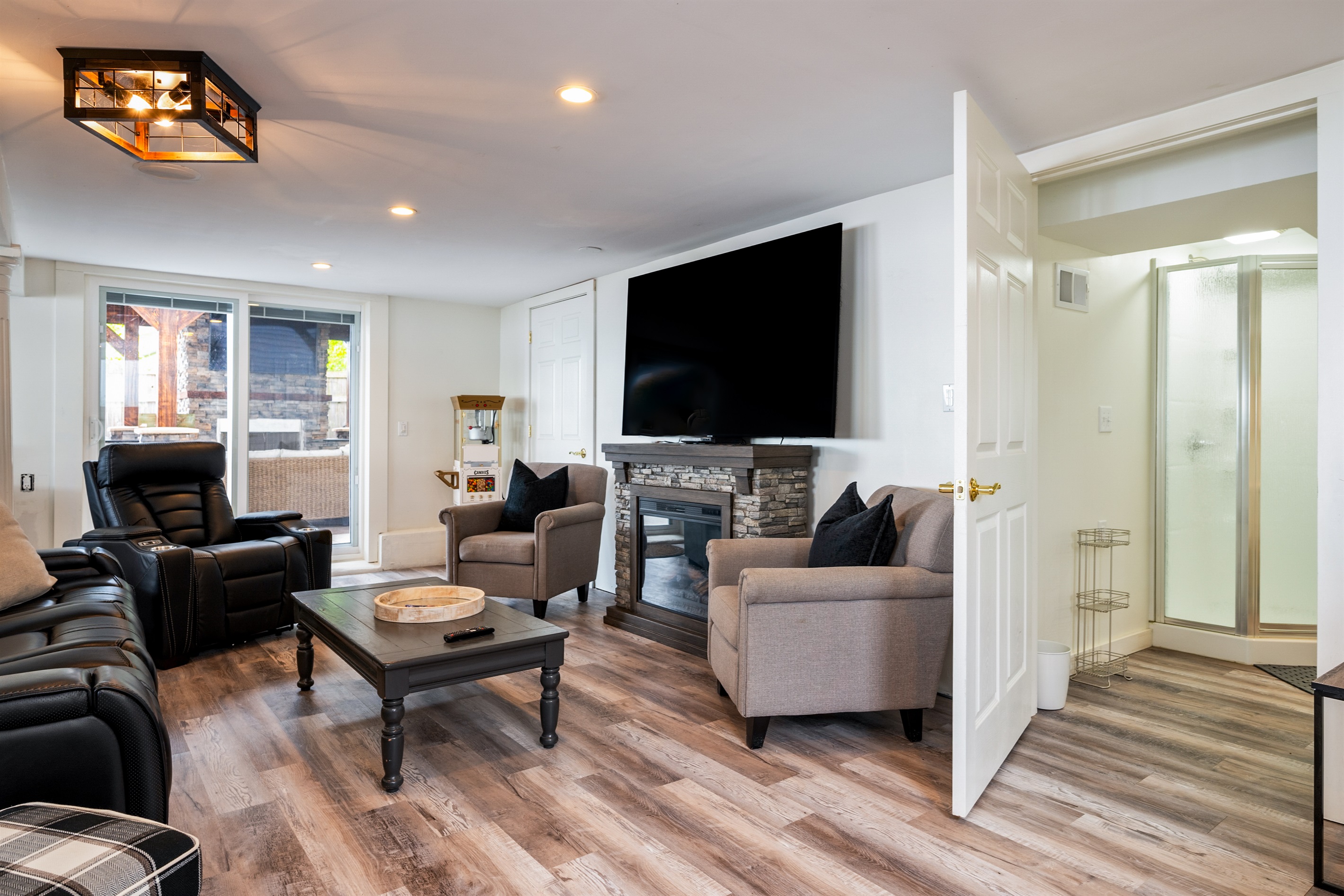 Kick back in this inviting living room with leather recliners, a stone fireplace, and big-screen TV 🔥🎬🛋️
