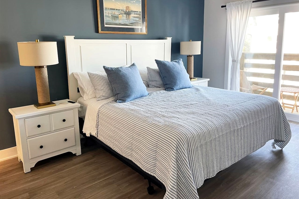 Relax in the spacious primary suite featuring a comfortable king bed, elegant décor, and direct access to the private balcony.