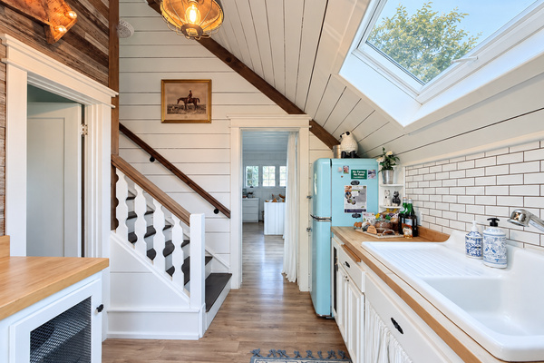 Small kitchen, big personality. An operable skylight, original 1930s drainboard sink and retro turquoise refrigerator are just a few of the delightful finds tucked inside.