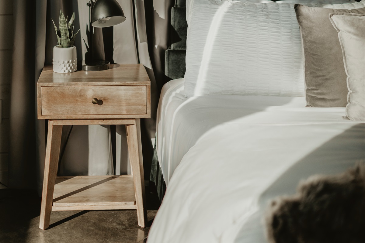 A simple, serene bedroom corner with warm wood accents and soft linens. Perfect for quiet mornings, late-night reads, and restful nights in a cozy cabin retreat.