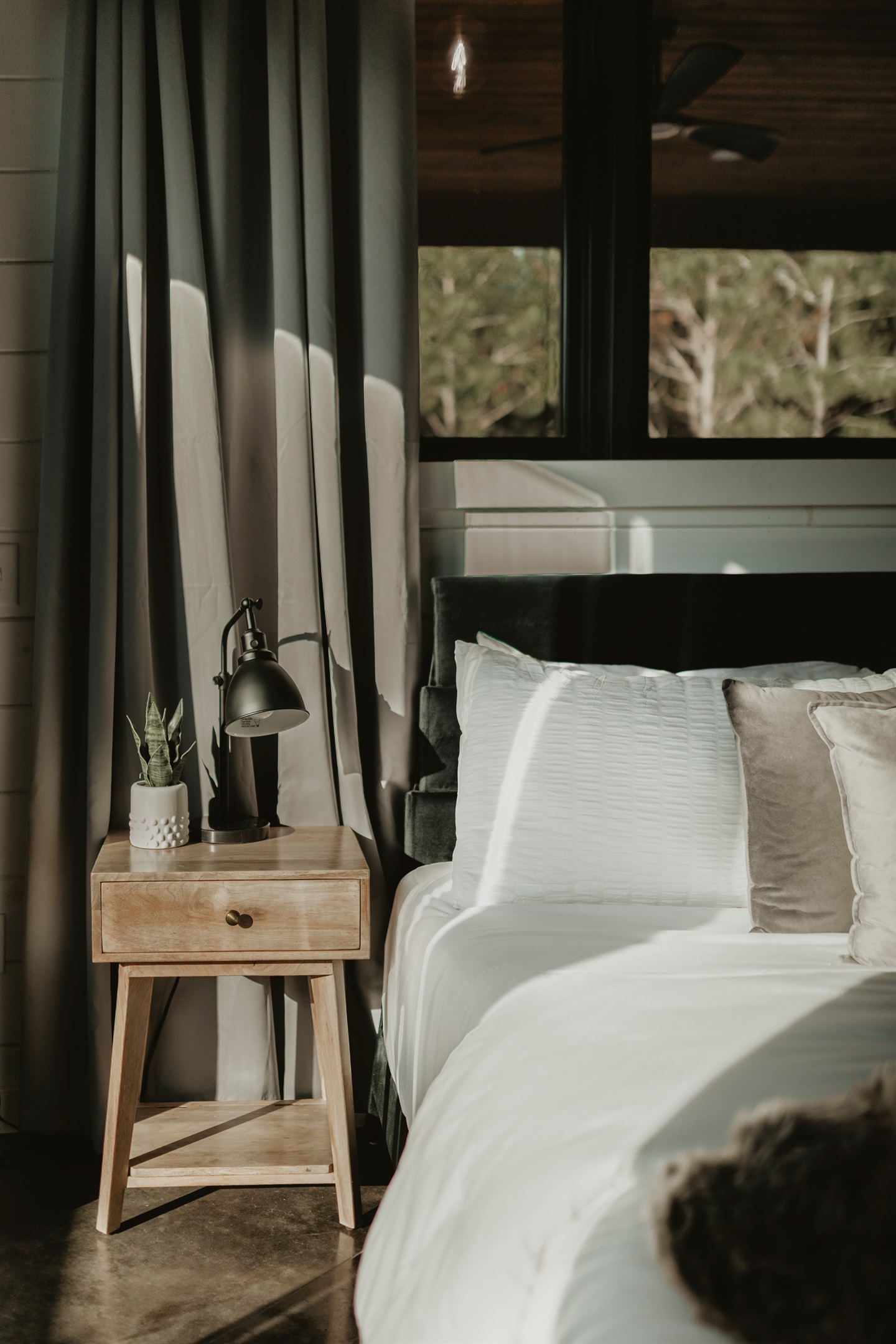 A simple, serene bedroom corner with warm wood accents and soft linens. Perfect for quiet mornings, late-night reads, and restful nights in a cozy cabin retreat.