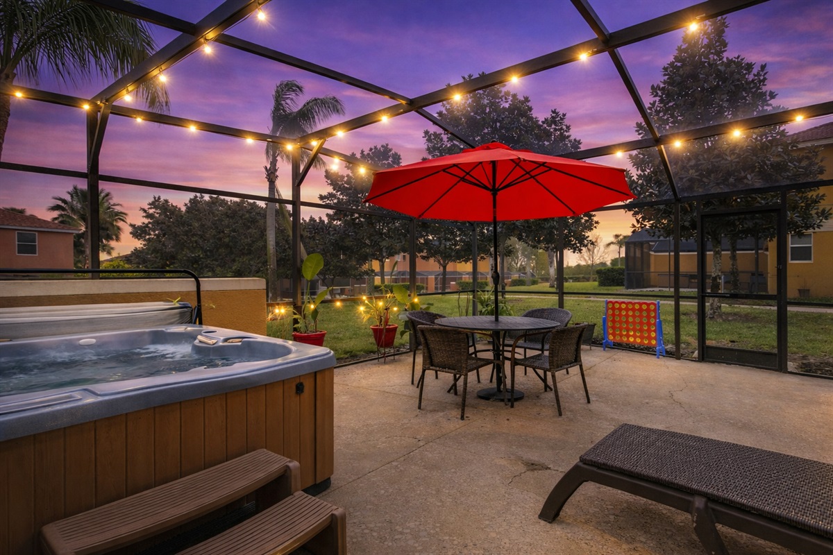 Private screened lanai with hot tub spa, outdoor dining table, and shaded seating — perfect after a Disney day