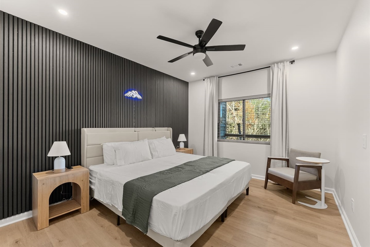 Two flexible twin beds that can convert into a king or stay separate, featuring modern nightstands, wall panels, and a spacious closet—stylish and adaptable for any stay.