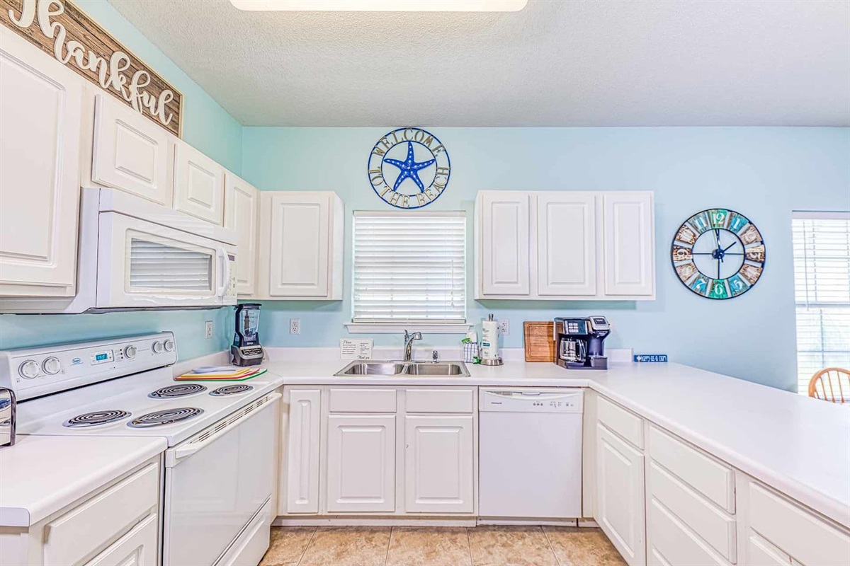 Kitchen: Bright and cheerful space with modern appliances and beachy decor for culinary delights!