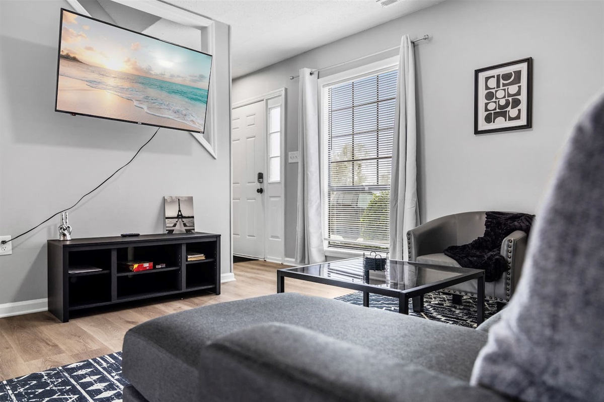 Relax and unwind with a sleek wall-mounted Smart TV and stylish seating perfect for movie nights.