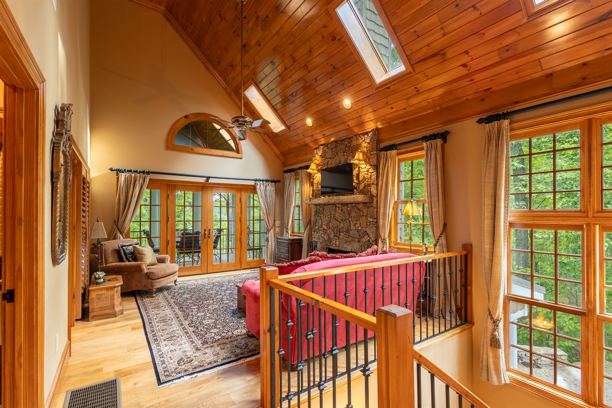 Soaring wood ceilings, a stunning stone fireplace, and warm natural light create the perfect mountain lodge atmosphere for relaxing after a day of adventure.