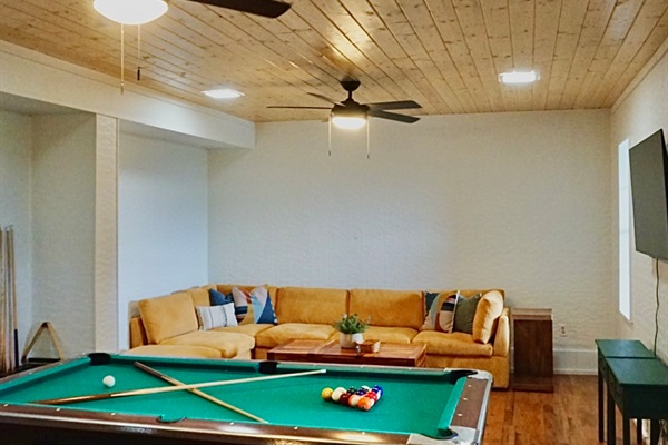 Enjoy billiards, plush seating, and a vibrant wooden ceiling for endless fun!
